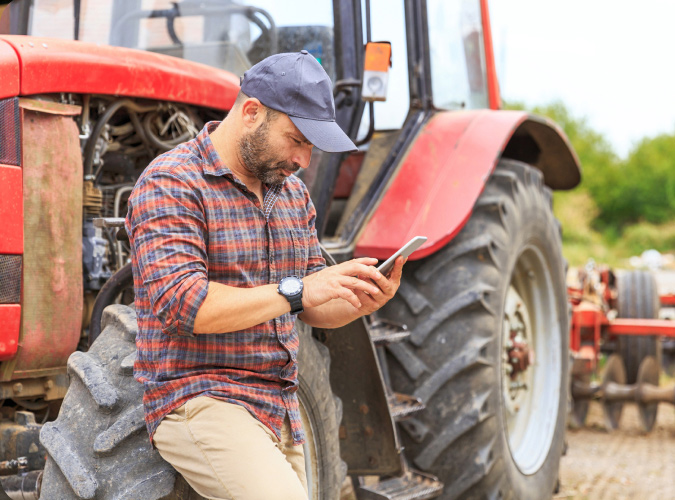 Farmer leaning against tractor.